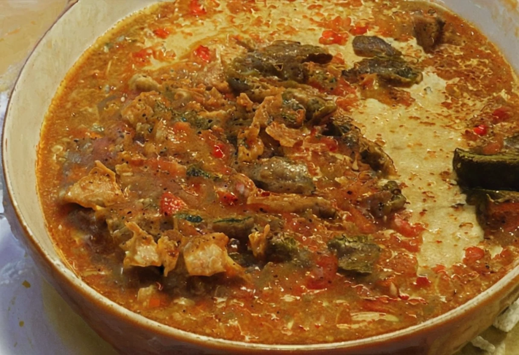 Guiso de hallacas venezolanas cocinándose en una olla, con carne de res, cerdo y pollo mezclados con verduras, especias y condimentos tradicionales